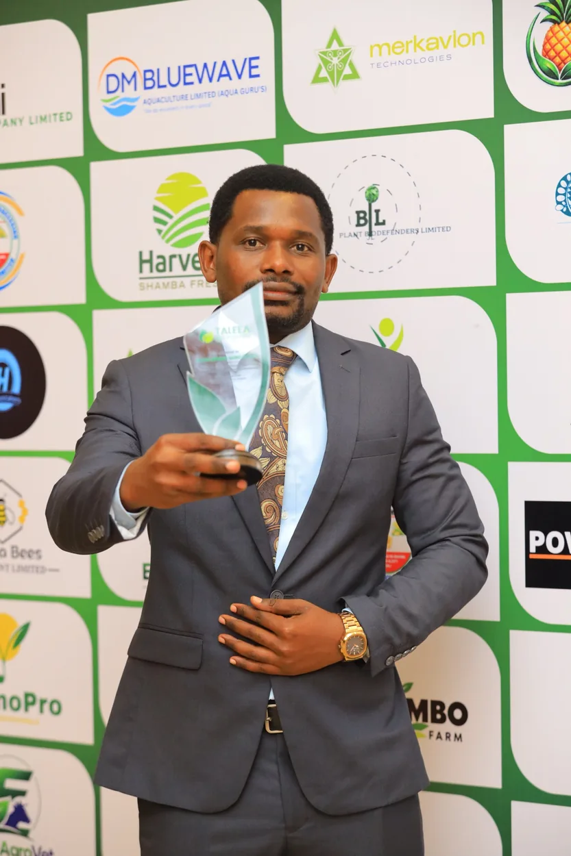 Chris Mbena Agro representative holding an agricultural excellence award